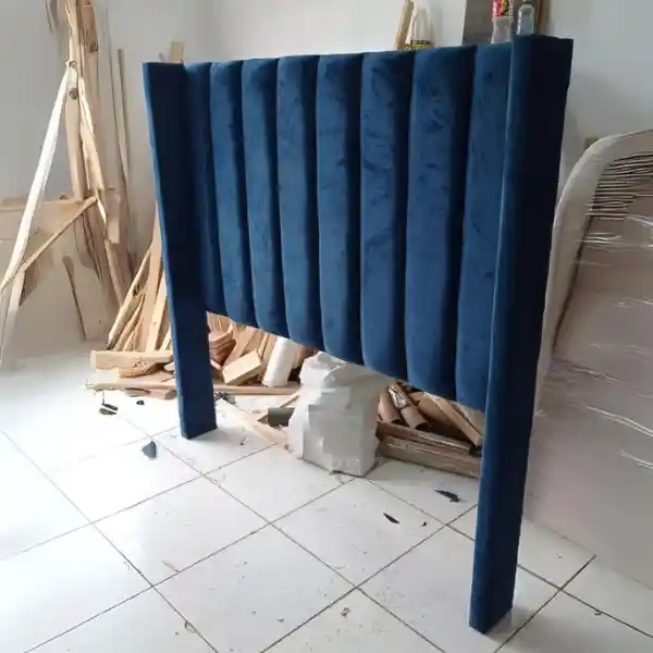 Custom blue velvet bed headboard upholstery with vertical panels in Dubai